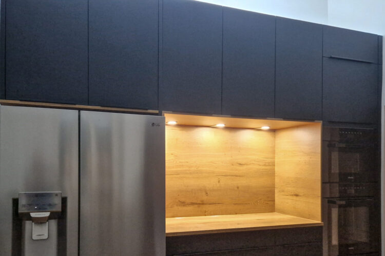 Häcker Küchenwand in schwarz mit zweiflügeligem LG Kühlschrank in Edelstahloptik und Elektrogeräten von Miele.