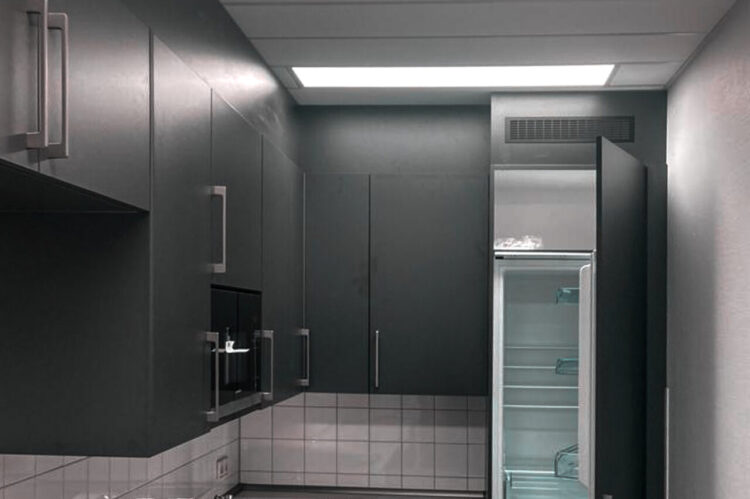 Büroküche von Häcker in Anthrazit mit Hochkühlschrank und heller Arbeitsplatte