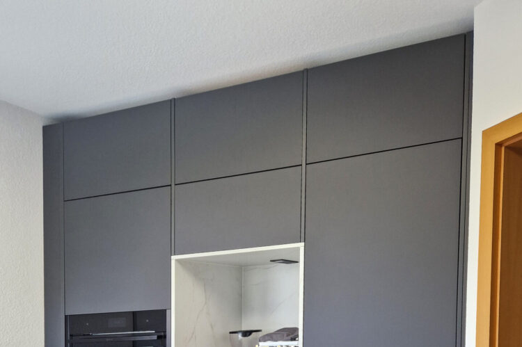 moderne Häcker Küche anthrazit mit schwarzem Backofen und integrierter Nische für Küchengeräte in Marmoroptik
