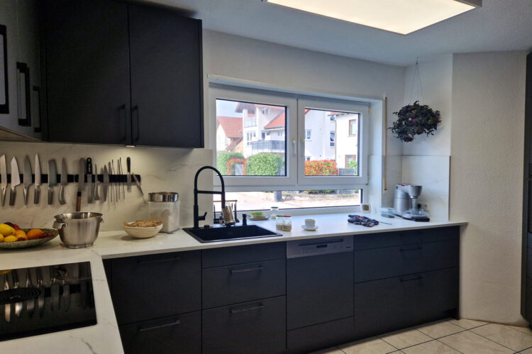 Häcker Küche anthrazit, modern mit Arbeitsplatte in Marmoroptik mit Neff Kochfeld und schwarzem Spülbecken und schwarzer Armatur
