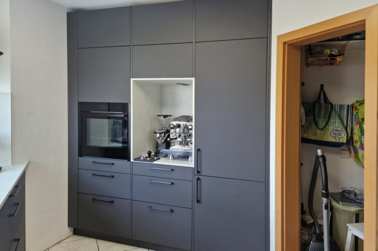 moderne Häcker Küche anthrazit, mit Deckenhohen Schränken, schwarzem Ofen und Nische in Marmoroptik, ausreichend Stauraum